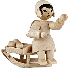 Girl on the sledge with christmas ornaments • natural